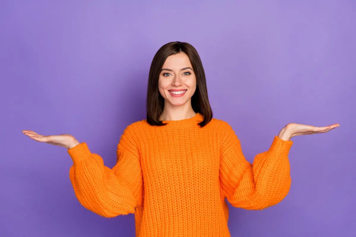 A woman weighing two options, one in each open hand