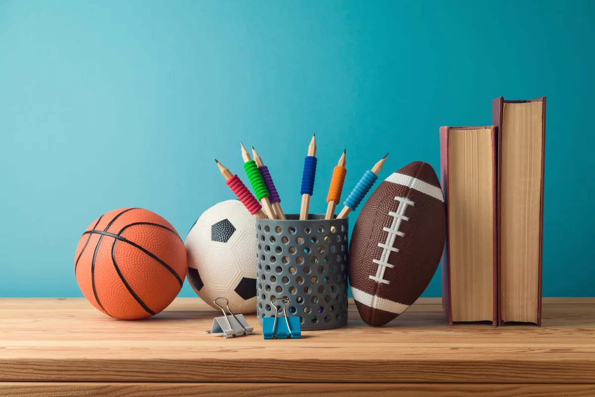 A basketball, soccer ball and football on a desk