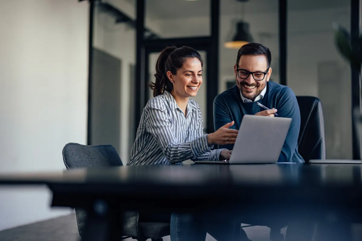 Two people working together at a laptop